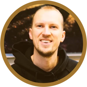 Smiling man in a black hoodie.