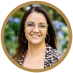 Smiling woman with glasses in a leopard print jacket.