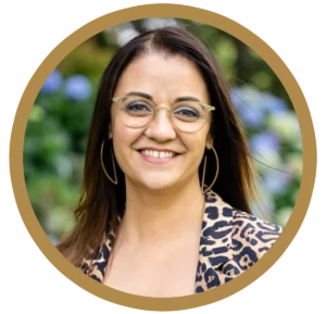 Smiling woman with glasses in a leopard print jacket.